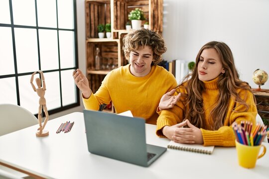 Young caucasian couple having online art class at home