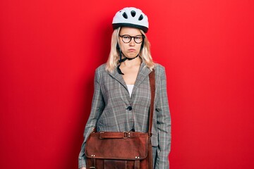 Beautiful caucasian blonde business woman wearing bike helmet skeptic and nervous, frowning upset because of problem. negative person.