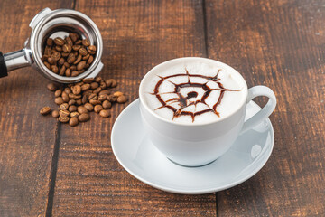 Fresh delicious cappuccino coffee on old wooden table
