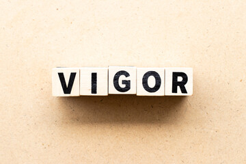 Letter block in word vigor on wood background