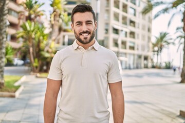 Fototapeta premium Young hispanic man smiling confident walking at street