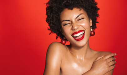Portrait of beautiful black woman with afro curly hairstyle, red lipstick and glowing healthy skin,...