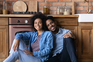 Portrait of smiling bonding millennial generation African ethnicity multiracial family couple...