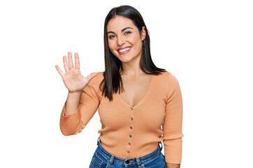 Young hispanic woman wearing casual clothes showing and pointing up with fingers number five while smiling confident and happy.