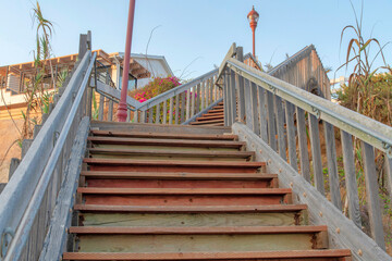 Steps of a wooden stairs with metal handrail at Oceanside, California