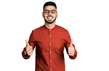 Young hispanic man with beard wearing business shirt and glasses success sign doing positive...