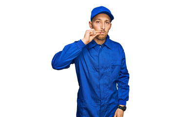 Bald man with beard wearing builder jumpsuit uniform mouth and lips shut as zip with fingers. secret and silent, taboo talking
