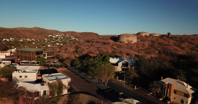 4K aerial Windhoek capital residential central hilly district bright sunset drone video, blooming Jacaranda trees, upmarket houses, old white walls German mansions in Khomas Region, central Namibia