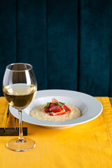 glass of wine and risotto with strawberries in the restaurant