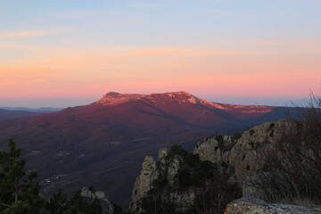 Obraz premium Landscape of the sun rising in the mountains. Red reflexes from the sun on the mountainsides. Areal view