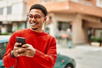 Handsome african american man outdoors using smartphone typing a message