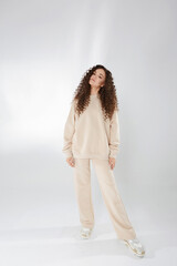 Full-length portrait of a young woman with afro hair in a trendy outfit over white background