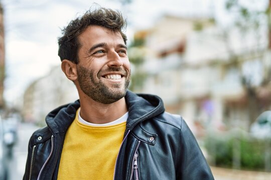 Handsome hispanic man with beard smiling happy outdoors