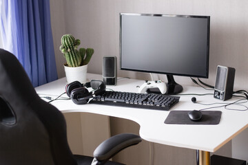 Desktop computer of gamer  with black monitor, console, headphones and chair 