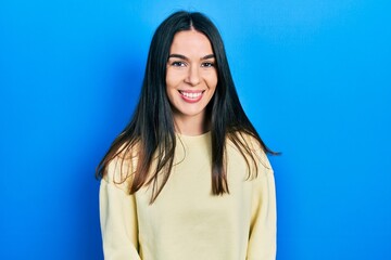 Fototapeta premium Young brunette woman wearing casual sweatshirt with a happy and cool smile on face. lucky person.