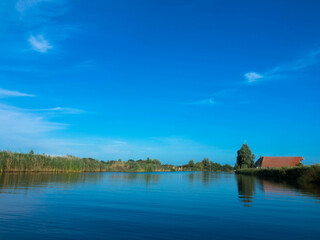 Panorama from a typical dutch water canal Kükhernster Feart between Leeuwarden and Groningen in Friesland, The Netherlands