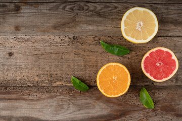 Citruses on a wooden background. Cut fruit. Juicy grapefruit and orange. View from above