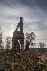 Brick remains of an old abandoned bell tower. An old abandoned brick structure in the forest. Brick wall.