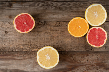 Fototapeta na wymiar Citruses on a wooden background. Cut fruit. Juicy grapefruit and orange. View from above