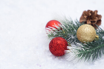 Christmas composition of Christmas tree toy red and gold ball snow background tree branch cone