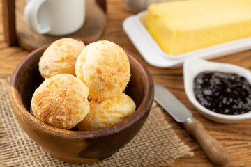 Typical brazilian cheese bun in a bowl, coffee, jam and butter