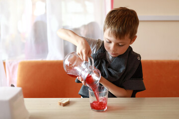Boy pouring juice into glass