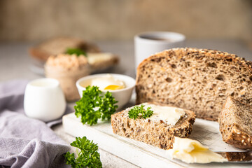 Freshly baked artisan multigrain bread with butter and pate. Breakfast with coffee, sliced bread, butter and liver pate.