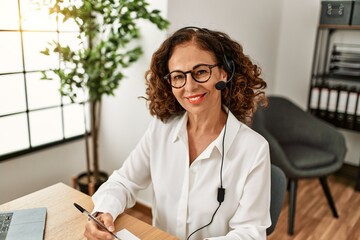 Middle age hispanic woman smiling confident working at office