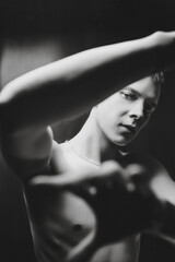 Young man posing to the camera with a naked torso for advertising. Black and white photography. Emotions, feelings. There is room for text. 