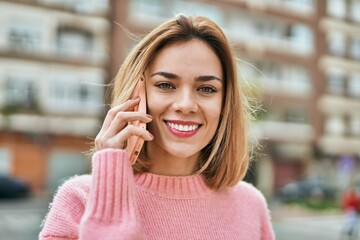 Young caucasian girl smiling happy talking on the smartphone at the city.