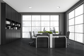 Four workspaces arranged in pairs in dark grey panoramic office