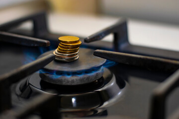 Gas stove burner with coins. A burning gas burner. The concept of paying for gas.