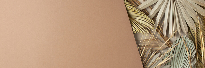 Tropical natural background with palm leaf on brown. Flat lay, copy space