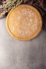 Cutting board and scattered flour powder on stone background top table. Wooden pizza board