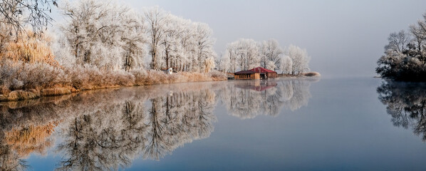 House by the lake. The transition of nature from autumn to winter. Foggy and sunny morning on the...