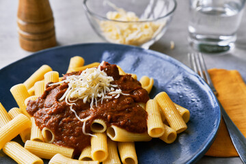  Plate of macaroni italian pasta with tomato sauce and cheese on a concrete surface