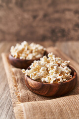 Fototapeta na wymiar Bowls of salty popcorns on a wooden surface