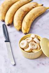  Bowls of slices of banana on a marble table