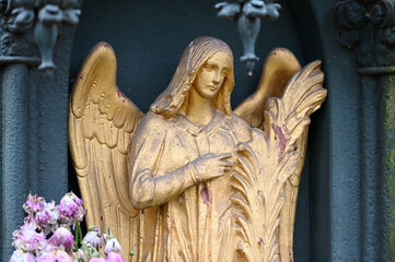 A golden sandstone angel in front of an old crypt in Berlin-Germany.