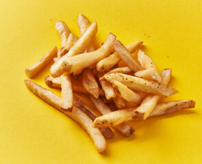  Bunch of french fried potatoes on a yellow background