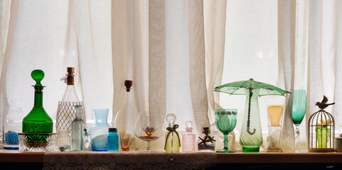 Various empty retro glasses and bottles on the window sill