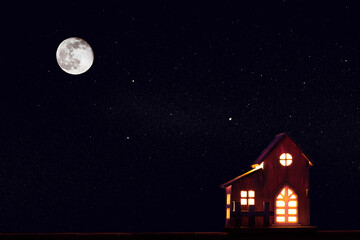 Winter one rural wooden house at christmas stars night with huge moon. Copy space.