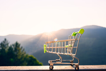 Shopping wagon cart in the mountain in sunbeams of sunrise. Eco, bio food, product, water, organic...