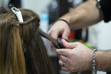Fototapeta premium Shirring long hair in a hairdresser's shop is a frequently ordered procedure. As it helps the hair look more voluminous