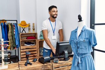 Young arab man shopkeeper smiling confident working at clothing store