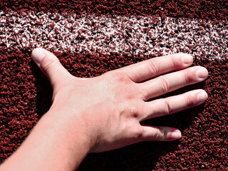 Runner in start position. Hands on starting line. Sport