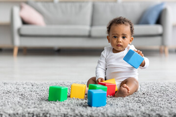 Portrait Of Adorable Black Infant Baby Playing With Building Blocks At Home