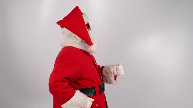 Santa claus in sunglasses runs on a white background. Merry Christmas.