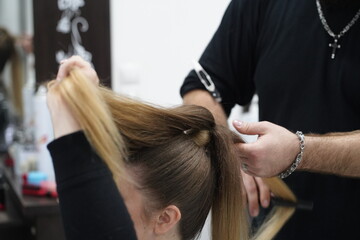 Work in a hairdressing salon. High tail. Measurement with fingers by hairdresser before start.