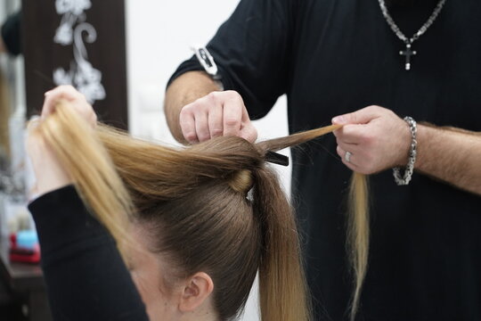 Work in a hairdressing salon. High tail. Measurement with fingers by hairdresser before start.